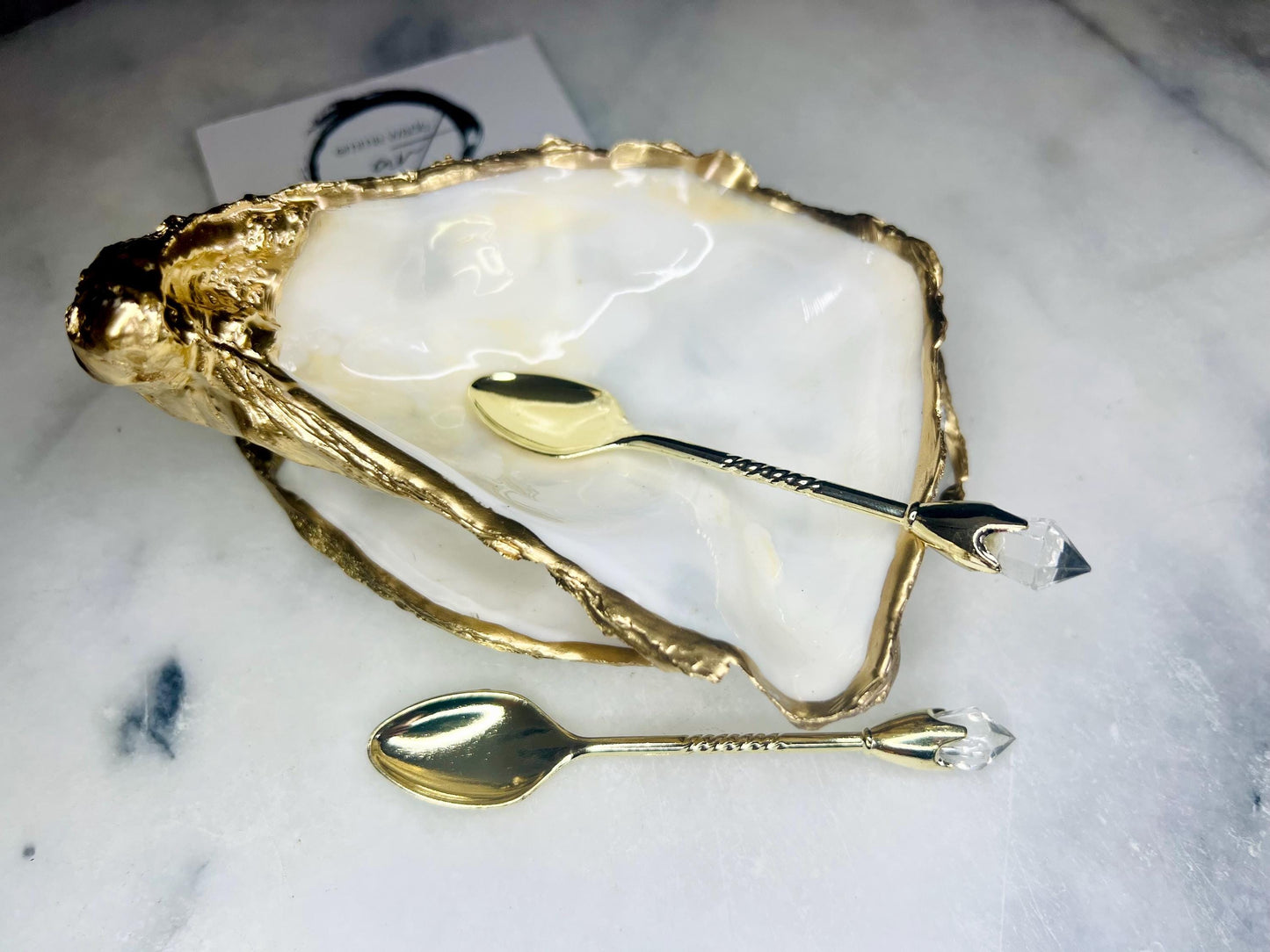 Extra large Dorset oyster shell serving dish set with natural pearl interior and hand-applied gold leaf edging, featuring a cupped XL oyster shell with matching flat shell base. Luxury coastal home décor ideal as a sugar dish, serving bowl, coffee station accessory, or elegant host gift. Handmade using sustainably sourced UK oyster shells and finished with glossy resin and optional gold serving accessories.