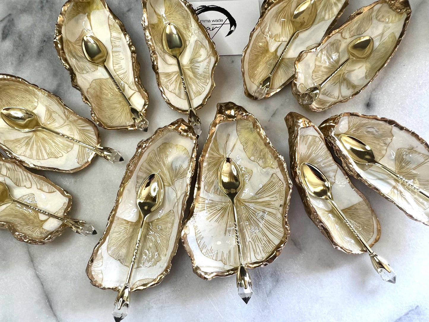 Pair of handmade Dorset oyster shell salt and pepper pinch pots featuring elegant Japanese Ginkgo floral artwork in soft gold and pearl tones with hand-applied gold leaf edging. Coastal luxury cruet set sealed in glossy Crystal resin with optional gold crystal spoons.