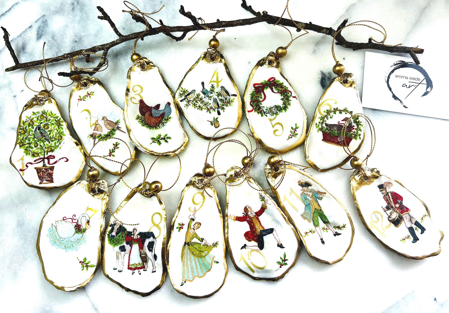 Handmade Twelve Days of Christmas oyster shell ornament set featuring all twelve traditional carol illustrations, finished with gold leaf edging, glossy resin and gold hanging cords. Coastal heirloom Christmas decorations handcrafted from Dorset oyster shells.