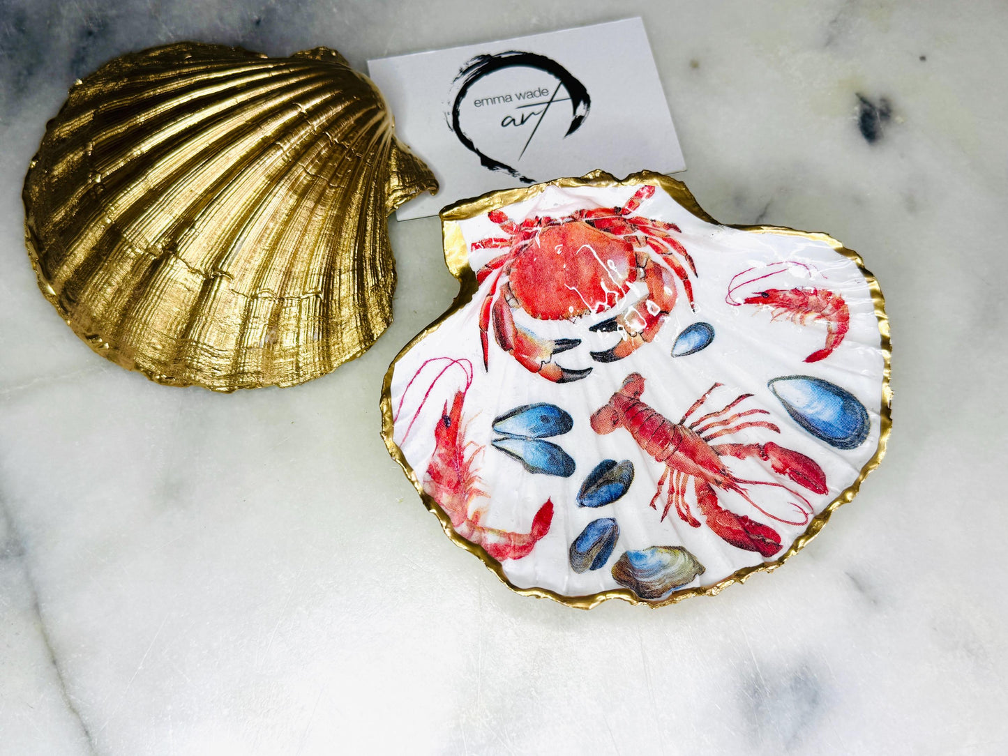 Handmade Dorset scallop shell trinket dish featuring a vibrant red crab and lobster coastal design, hand-gilded with real liquid gold leaf and sealed in crystal-clear glossy resin. Nautical shell jewellery dish inspired by the Dorset coastline, perfect as a ring holder, coastal home décor accent, seaside gift, or luxury beach house accessory.