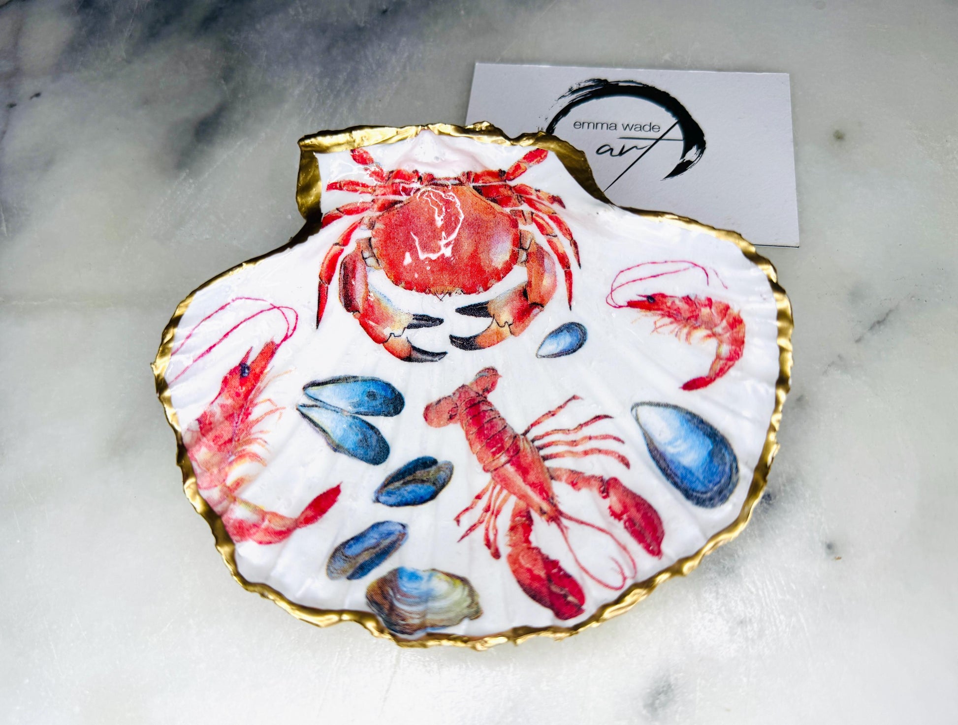 Handmade Dorset scallop shell trinket dish featuring a vibrant red crab and lobster coastal design, hand-gilded with real liquid gold leaf and sealed in crystal-clear glossy resin. Nautical shell jewellery dish inspired by the Dorset coastline, perfect as a ring holder, coastal home décor accent, seaside gift, or luxury beach house accessory.