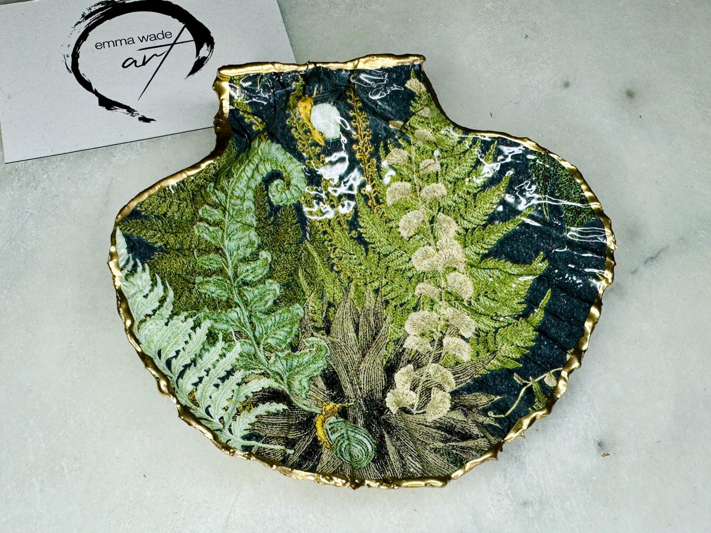 Handmade fern green scallop shell trinket dish with botanical forest fern design, gold leaf edging, and glossy resin finish. Natural Dorset shell jewellery dish inspired by woodland décor and cottagecore interiors, styled as a ring holder, trinket tray, or coastal nature-inspired gift.