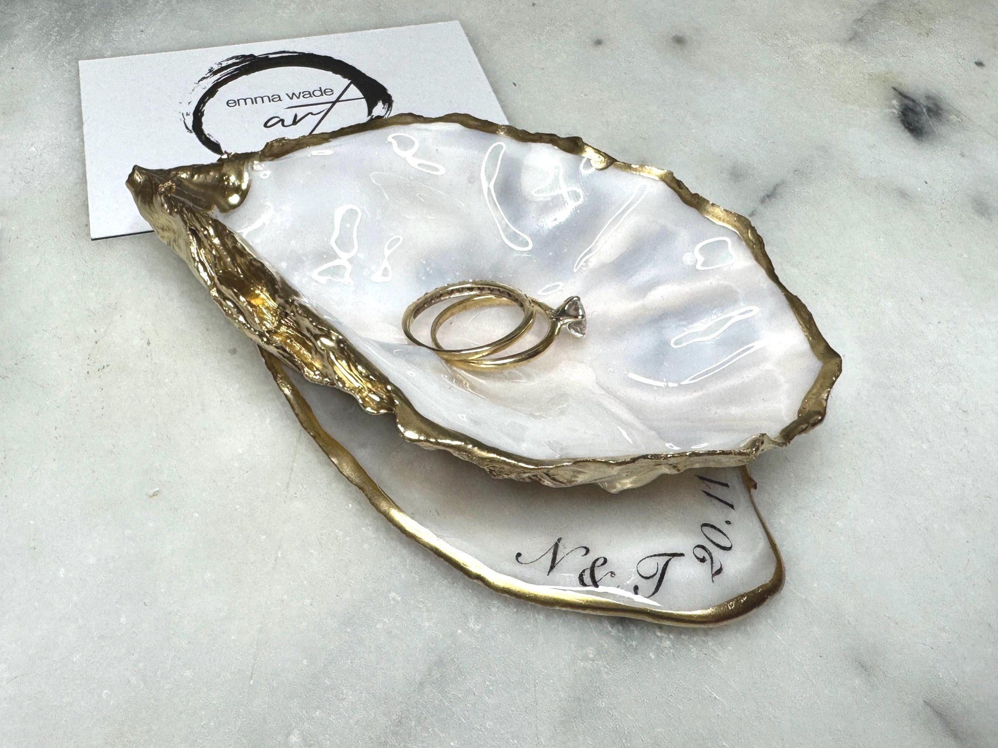 Handmade Dorset oyster shell jewellery dish set with a cupped oyster shell resting on a flat shell base, finished with natural pearl interiors and gold leaf edging. Personalised coastal trinket dish handcrafted in the UK, ideal for holding rings or jewellery. Elegant shell decor presented in sustainable gift packaging, perfect for weddings, anniversaries or special occasions.
