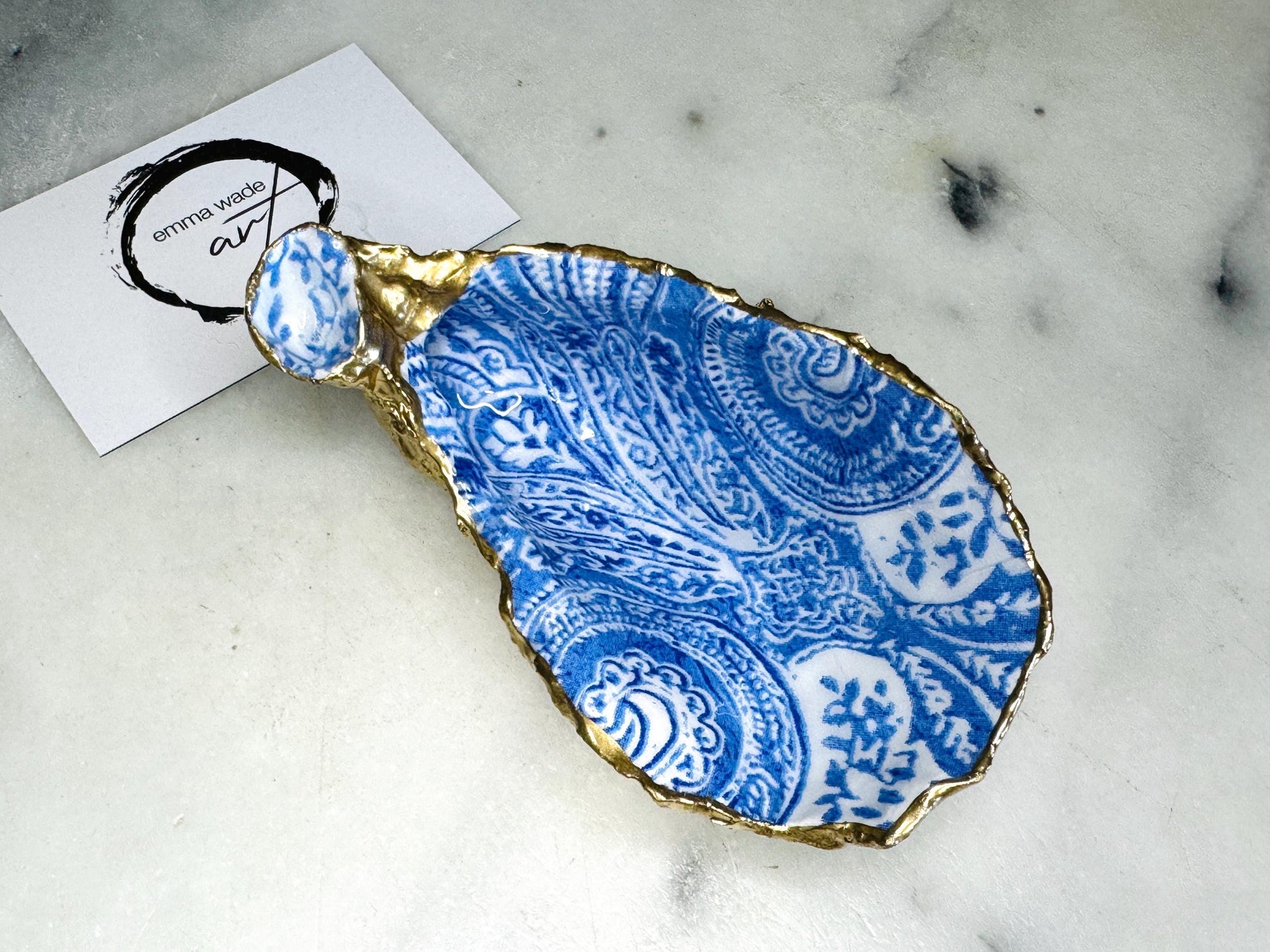 blue and white paisley oyster shell salt cellar set with gold leaf edging and matching gold crystal spoons. Handmade Dorset oyster shell pinch pots finished in glossy food safe resin. Coastal dining decor and luxury beach house table accessory.
