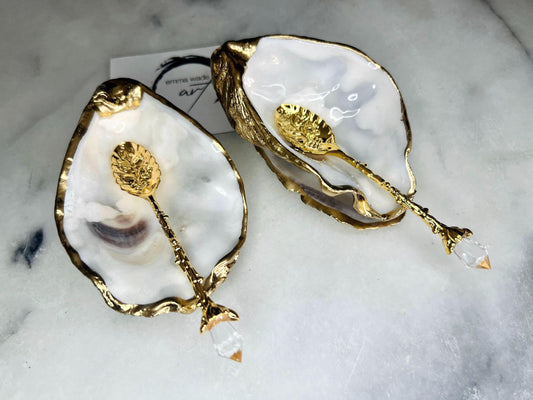 Handcrafted natural Dorset oyster shell salt and pepper pinch pot set with gold leaf edging and matching gold crystal spoons. Coastal luxury table décor featuring pearlescent oyster shells sealed with glossy Durable resin and presented as elegant artisan cruet dishes.