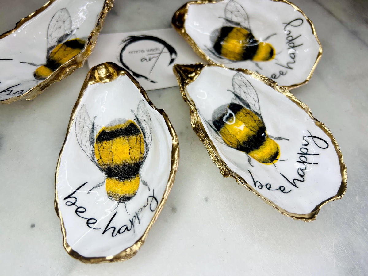 bee happy oyster shell trinket dish, Dorset oyster shell jewellery holder, handmade bee design coastal decor, gold leaf gilded oyster shell ornament, sustainable oyster shell dish UK, bumble bee oyster shell jewellery tray, nature inspired bee oyster shell gift, eco friendly oyster shell bathroom accessory, oyster shell salt and pepper pinch pot, unique bee themed oyster shell keepsake, handmade Dorset oyster shell decor, bee lover jewellery dish gift, coastal oyster shell art UK