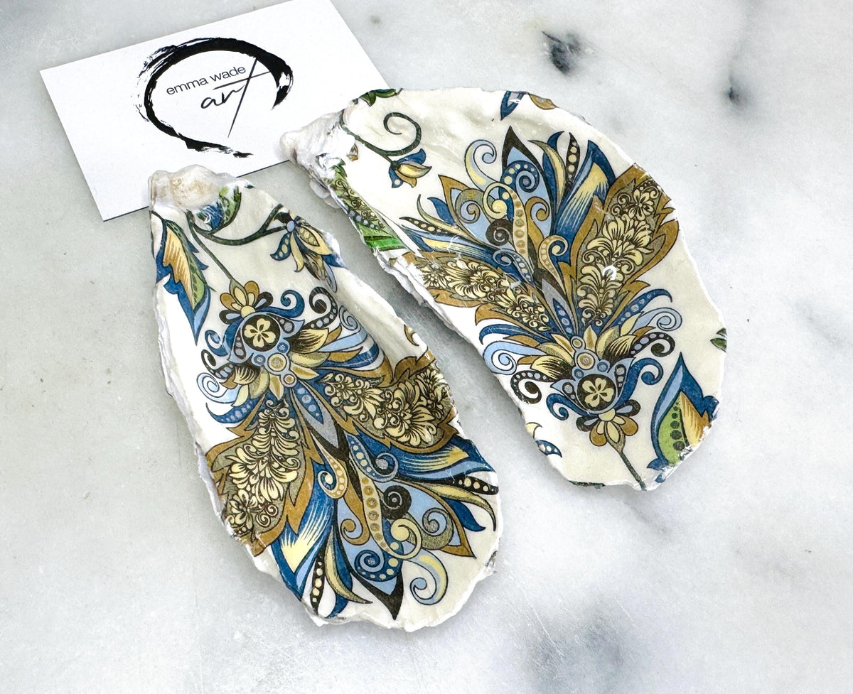 Handmade oyster shell salt and pepper dishes shown as a matching pair, decorated in a baroque gold design on natural Dorset shells, displayed on a light marble background as elegant coastal table decor and a unique hostess or wedding gift.
