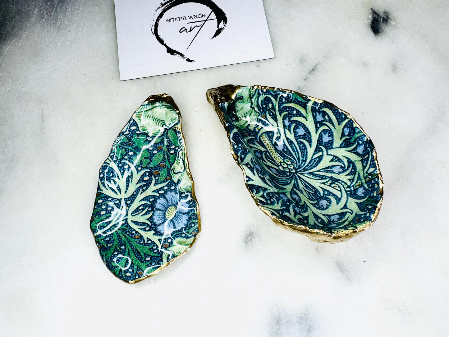 William Morris Seaweed design decoupage oyster shell ring dish with gold leaf exterior and glossy resin finish, shown on a light background. Natural Dorset oyster shell jewellery dish used as a ring holder, featuring a green and blue patterned interior, polished edges, and handcrafted coastal keepsake style. Ideal as an engagement ring dish, wedding ring holder, or jewellery trinket dish.