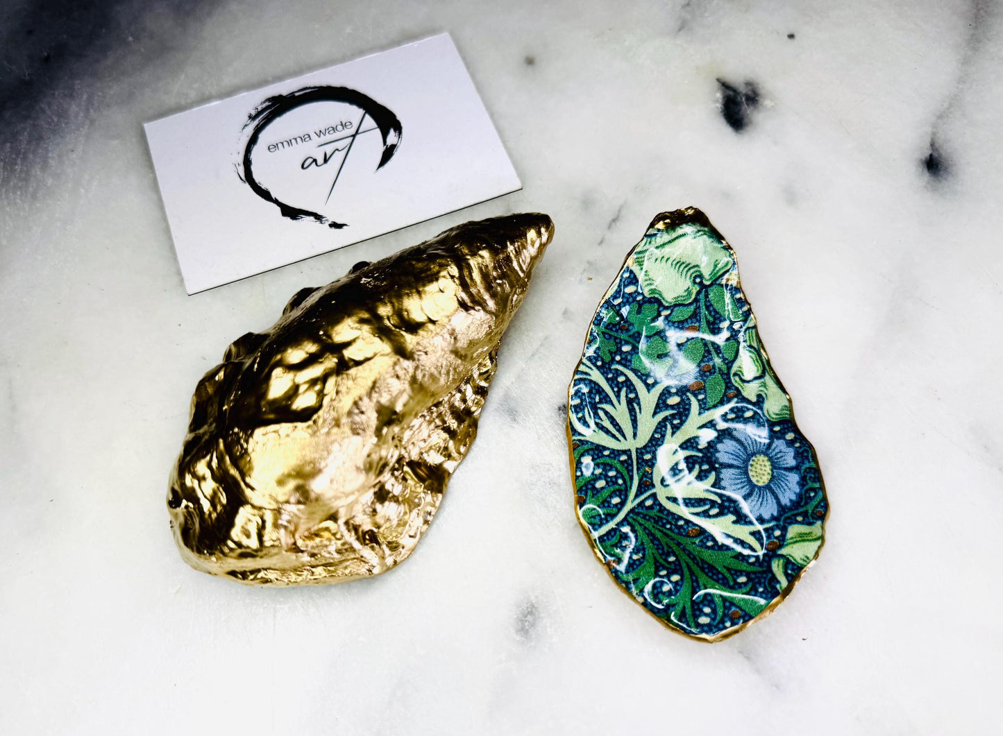 William Morris Seaweed design decoupage oyster shell ring dish with gold leaf exterior and glossy resin finish, shown on a light background. Natural Dorset oyster shell jewellery dish used as a ring holder, featuring a green and blue patterned interior, polished edges, and handcrafted coastal keepsake style. Ideal as an engagement ring dish, wedding ring holder, or jewellery trinket dish.