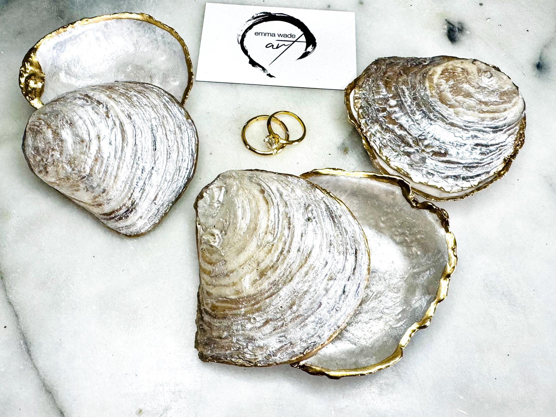 Handmade saddle oyster shell ring box with pearlescent interior and pearlised exterior, finished with gold leaf gilded edges and optional Swarovski pearl ring holder, luxury coastal wedding ring bearer box, proposal ring presentation dish, artisan shell jewellery holder styled on neutral marble background