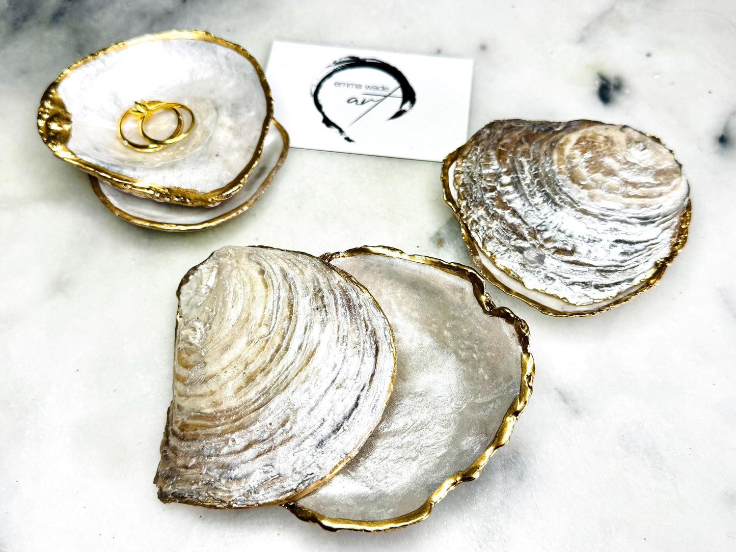 Handmade saddle oyster shell ring box with pearlescent interior and pearlised exterior, finished with gold leaf gilded edges and optional Swarovski pearl ring holder, luxury coastal wedding ring bearer box, proposal ring presentation dish, artisan shell jewellery holder styled on neutral marble background