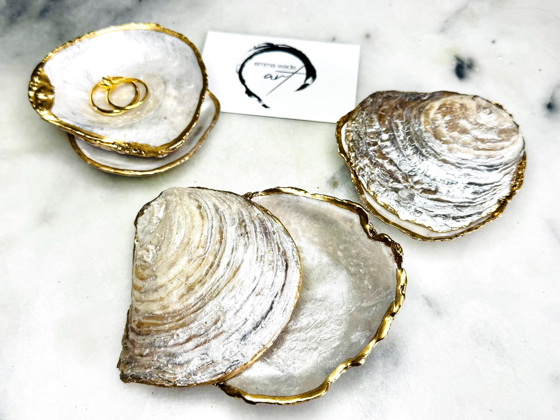 Handmade saddle oyster shell ring box with pearlescent interior and pearlised exterior, finished with gold leaf gilded edges and optional Swarovski pearl ring holder, luxury coastal wedding ring bearer box, proposal ring presentation dish, artisan shell jewellery holder styled on neutral marble background