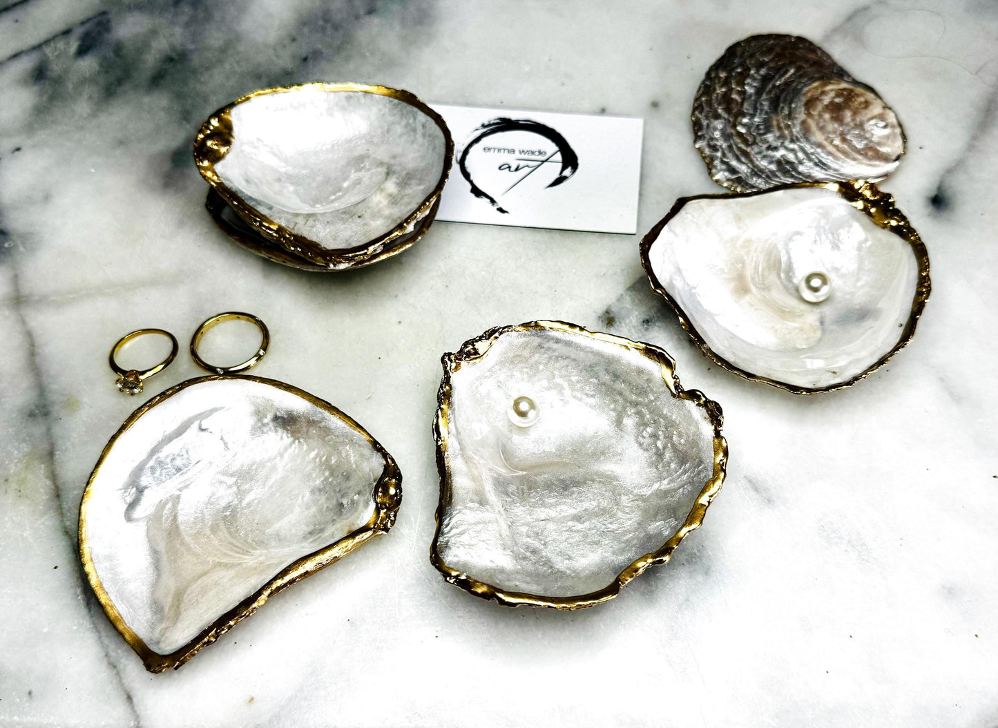 Handmade saddle oyster shell ring box with pearlescent interior and pearlised exterior, finished with gold leaf gilded edges and optional Swarovski pearl ring holder, luxury coastal wedding ring bearer box, proposal ring presentation dish, artisan shell jewellery holder styled on neutral marble background