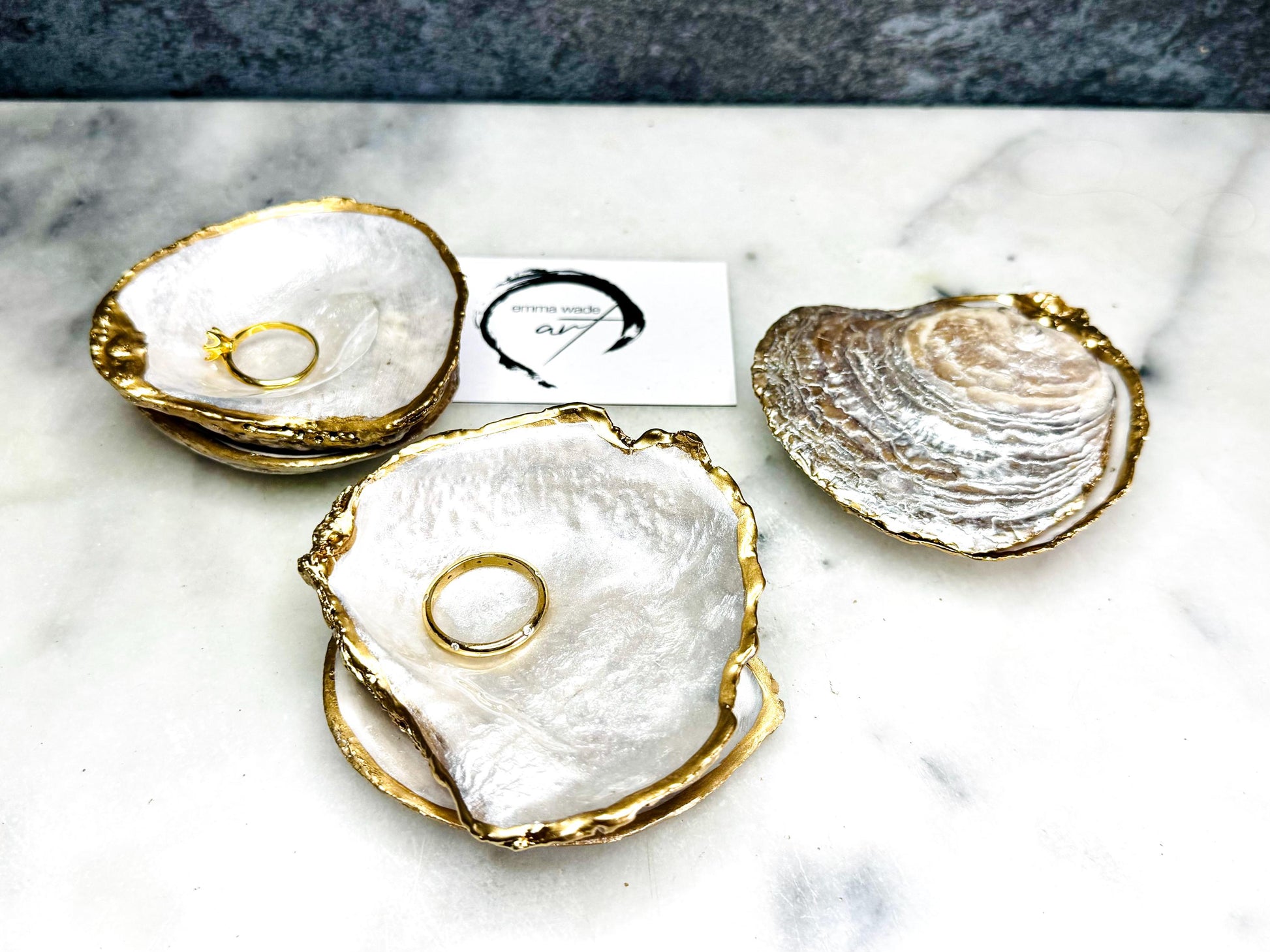 Handmade saddle oyster shell ring box with pearlescent interior and pearlised exterior, finished with gold leaf gilded edges and optional Swarovski pearl ring holder, luxury coastal wedding ring bearer box, proposal ring presentation dish, artisan shell jewellery holder styled on neutral marble background