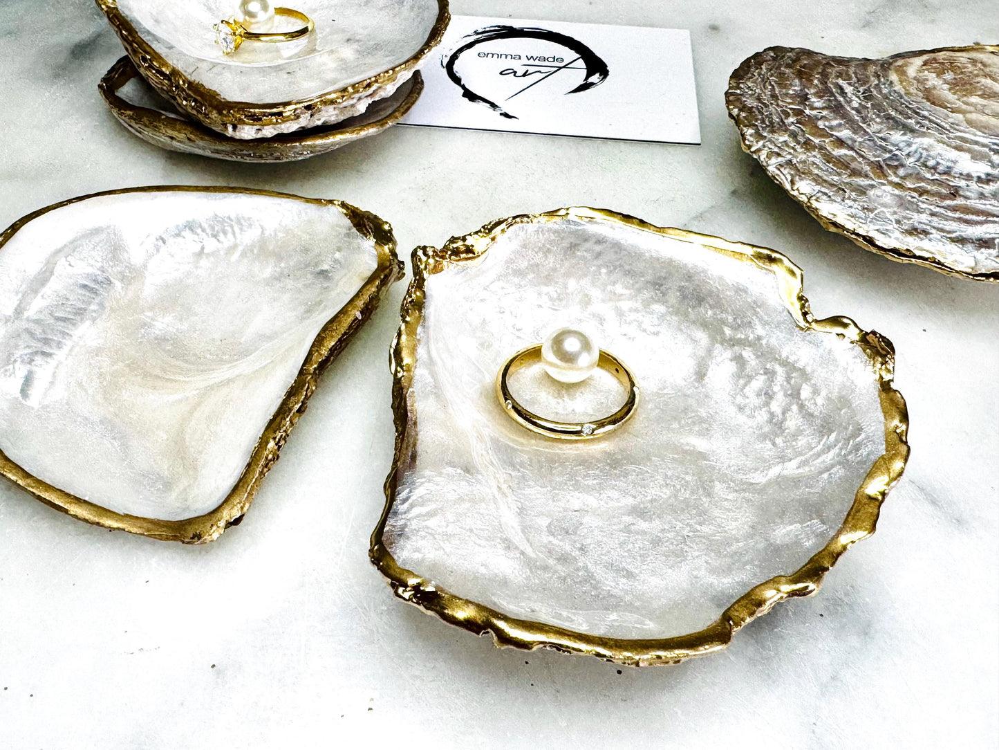 Luxury handmade saddle oyster shell ring box with soft pearlescent finish inside and out, gold leaf gilded rims and optional Swarovski pearl inset, unique coastal wedding ring bearer box, engagement proposal ring holder, decorative shell trinket dish displayed on light marble surface