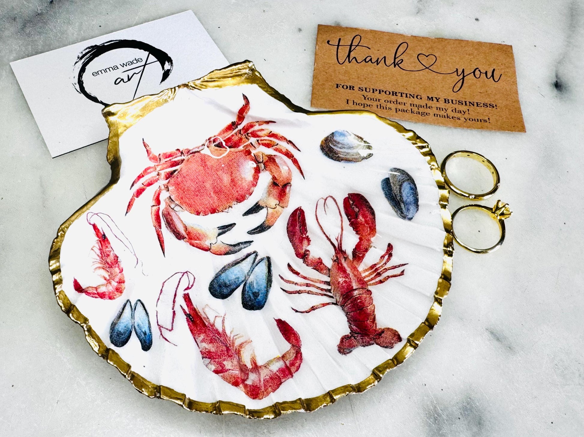 Handmade Dorset scallop shell trinket dish featuring a vibrant red crab and lobster coastal design, hand-gilded with real liquid gold leaf and sealed in crystal-clear glossy resin. Nautical shell jewellery dish inspired by the Dorset coastline, perfect as a ring holder, coastal home décor accent, seaside gift, or luxury beach house accessory.