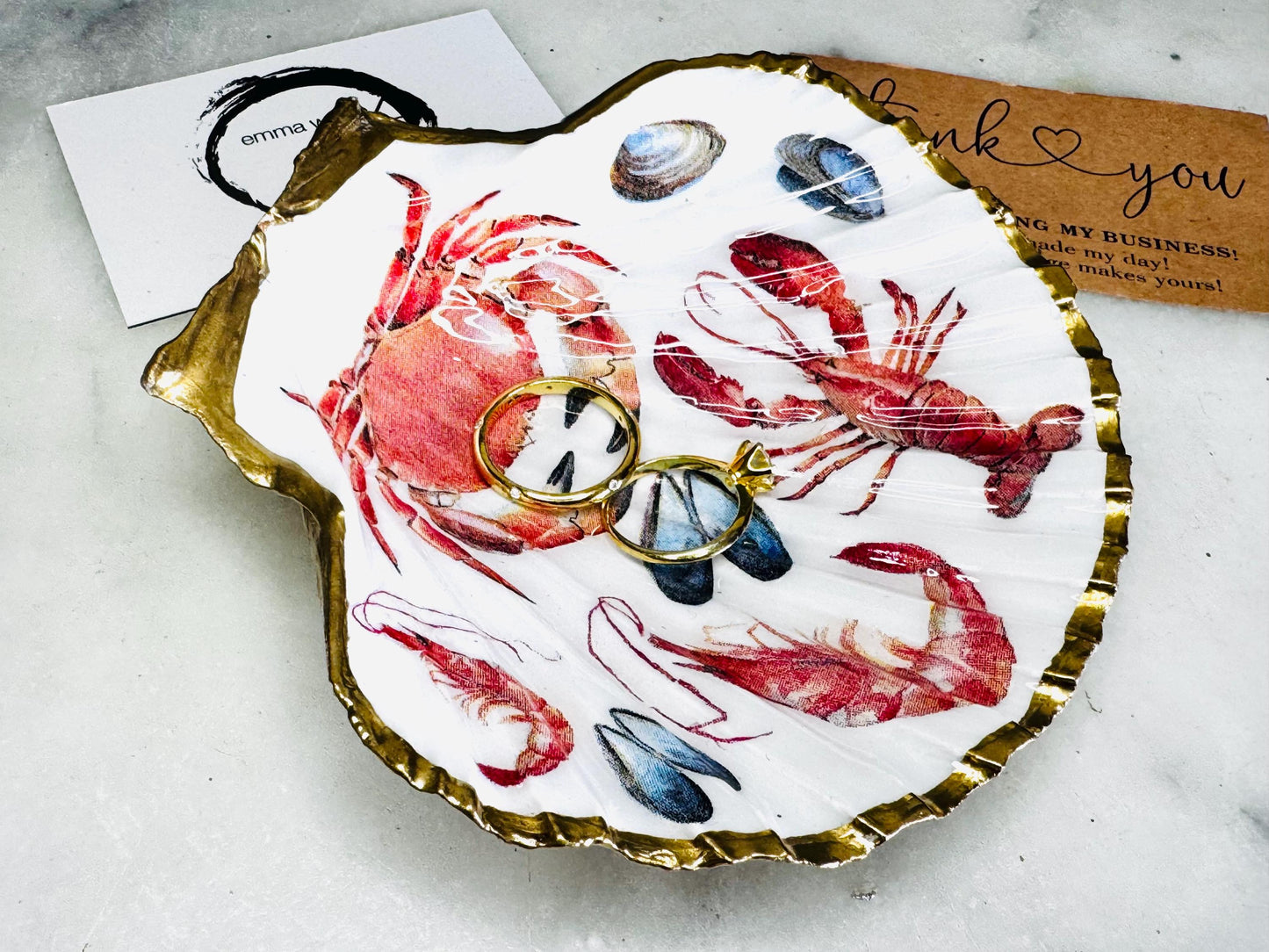 Handmade Dorset scallop shell trinket dish featuring a vibrant red crab and lobster coastal design, hand-gilded with real liquid gold leaf and sealed in crystal-clear glossy resin. Nautical shell jewellery dish inspired by the Dorset coastline, perfect as a ring holder, coastal home décor accent, seaside gift, or luxury beach house accessory.