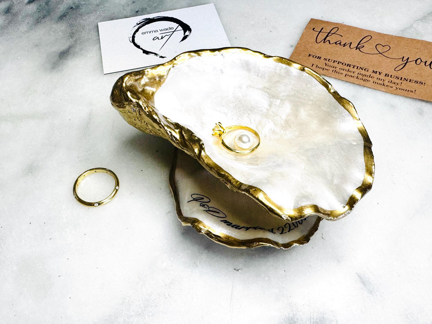 Handmade Dorset oyster shell jewellery dish set with a cupped oyster shell resting on a flat shell base, finished with natural pearl interiors and gold leaf edging. Personalised coastal trinket dish handcrafted in the UK, ideal for holding rings or jewellery. Elegant shell decor presented in sustainable gift packaging, perfect for weddings, anniversaries or special occasions.
