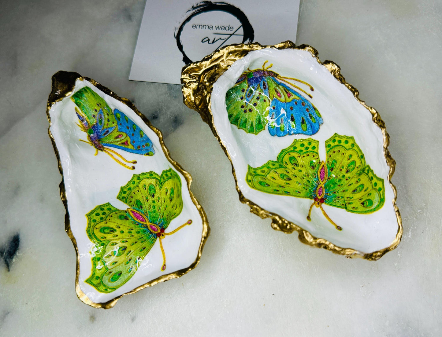 Handmade butterfly oyster shell trinket dish with colourful blue green and pink butterfly designs, edged and backed in gold leaf, Dorset coastal shell jewellery holder with glossy resin finish, luxury ring dish, coastal home decor gift, unique handmade shell dish for jewellery storage, beach house accessory, UK artisan oyster shell dish