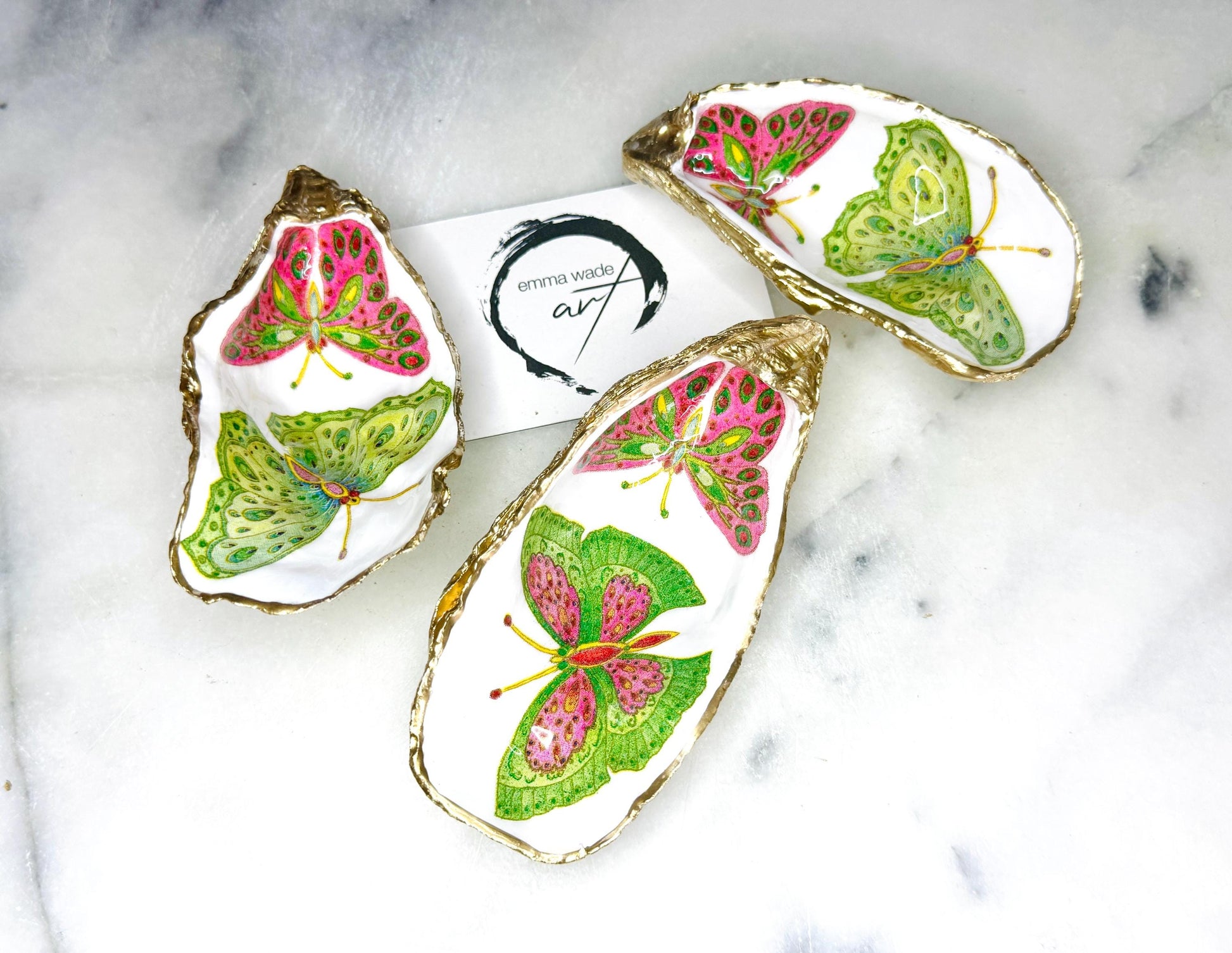 Handmade butterfly oyster shell trinket dish with colourful blue green and pink butterfly designs, edged and backed in gold leaf, Dorset coastal shell jewellery holder with glossy resin finish, luxury ring dish, coastal home decor gift, unique handmade shell dish for jewellery storage, beach house accessory, UK artisan oyster shell dish