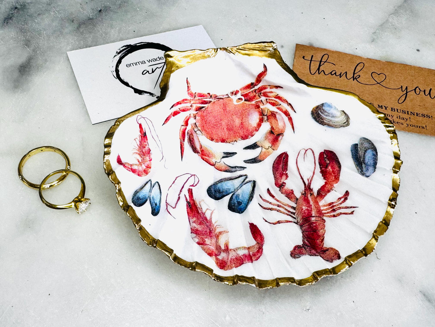 Handmade Dorset scallop shell trinket dish featuring a vibrant red crab and lobster coastal design, hand-gilded with real liquid gold leaf and sealed in crystal-clear glossy resin. Nautical shell jewellery dish inspired by the Dorset coastline, perfect as a ring holder, coastal home décor accent, seaside gift, or luxury beach house accessory.
