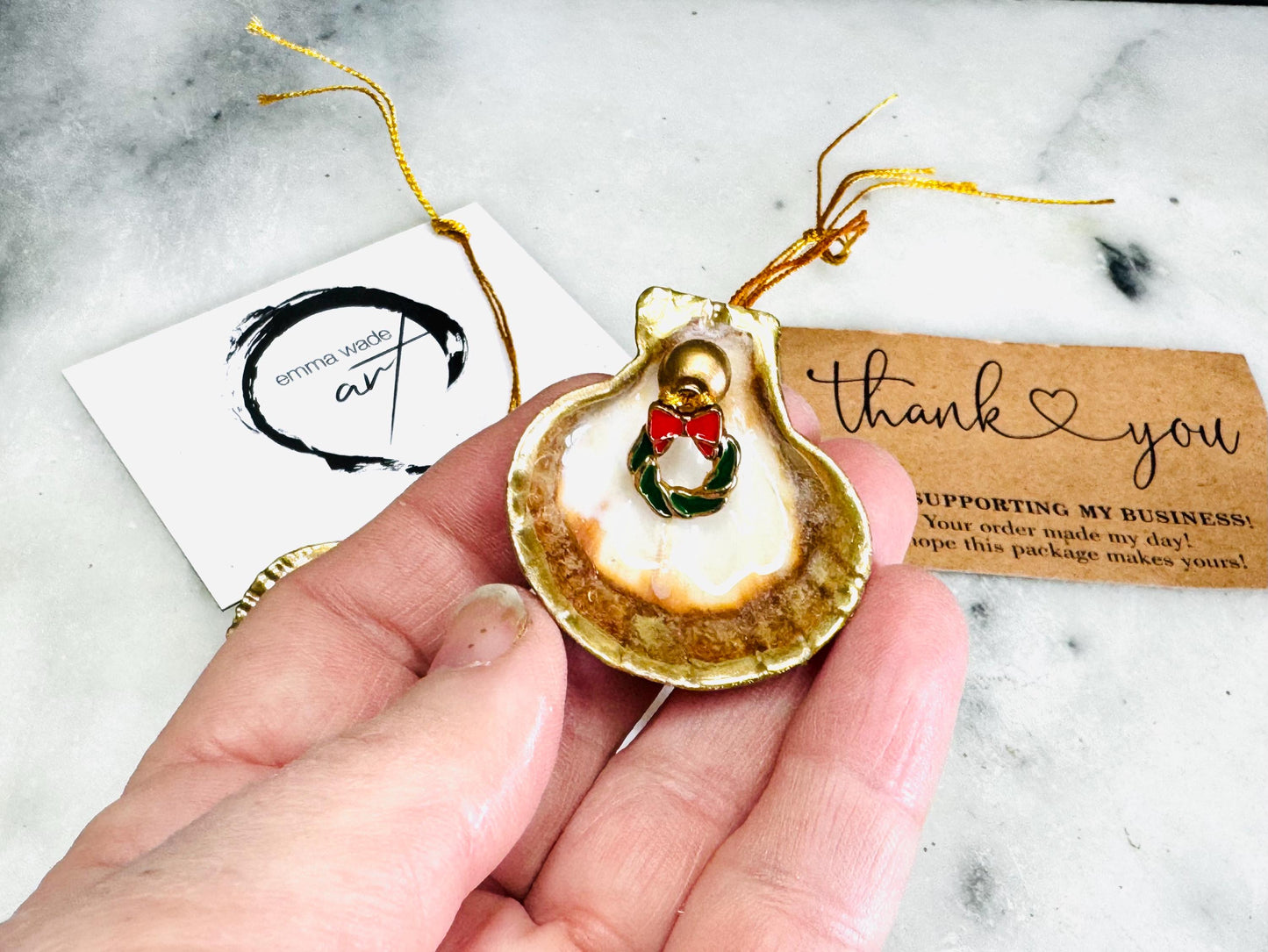 Handmade scallop shell Christmas ornaments with gold leaf edging and enamel charms, natural pearl shell decorations, Dorset shell baubles, festive tree decorations, stocking filler gifts, coastal Christmas decor, small hanging ornaments with gold string, unique handmade shell keepsake, wreath sleigh tree reindeer bell penguin charms, luxury Christmas gift idea