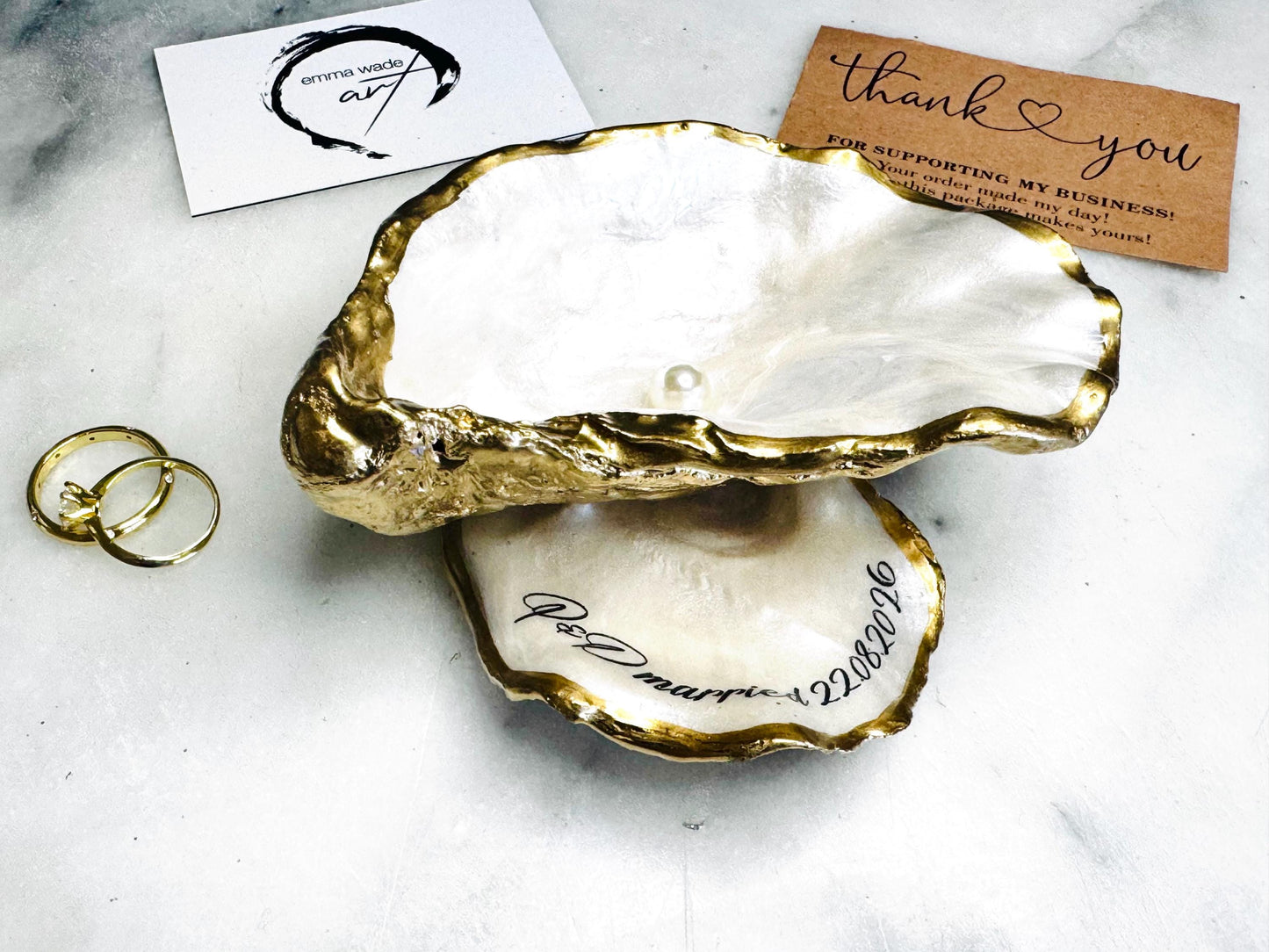 Handmade Dorset oyster shell jewellery dish set with a cupped oyster shell resting on a flat shell base, finished with natural pearl interiors and gold leaf edging. Personalised coastal trinket dish handcrafted in the UK, ideal for holding rings or jewellery. Elegant shell decor presented in sustainable gift packaging, perfect for weddings, anniversaries or special occasions.