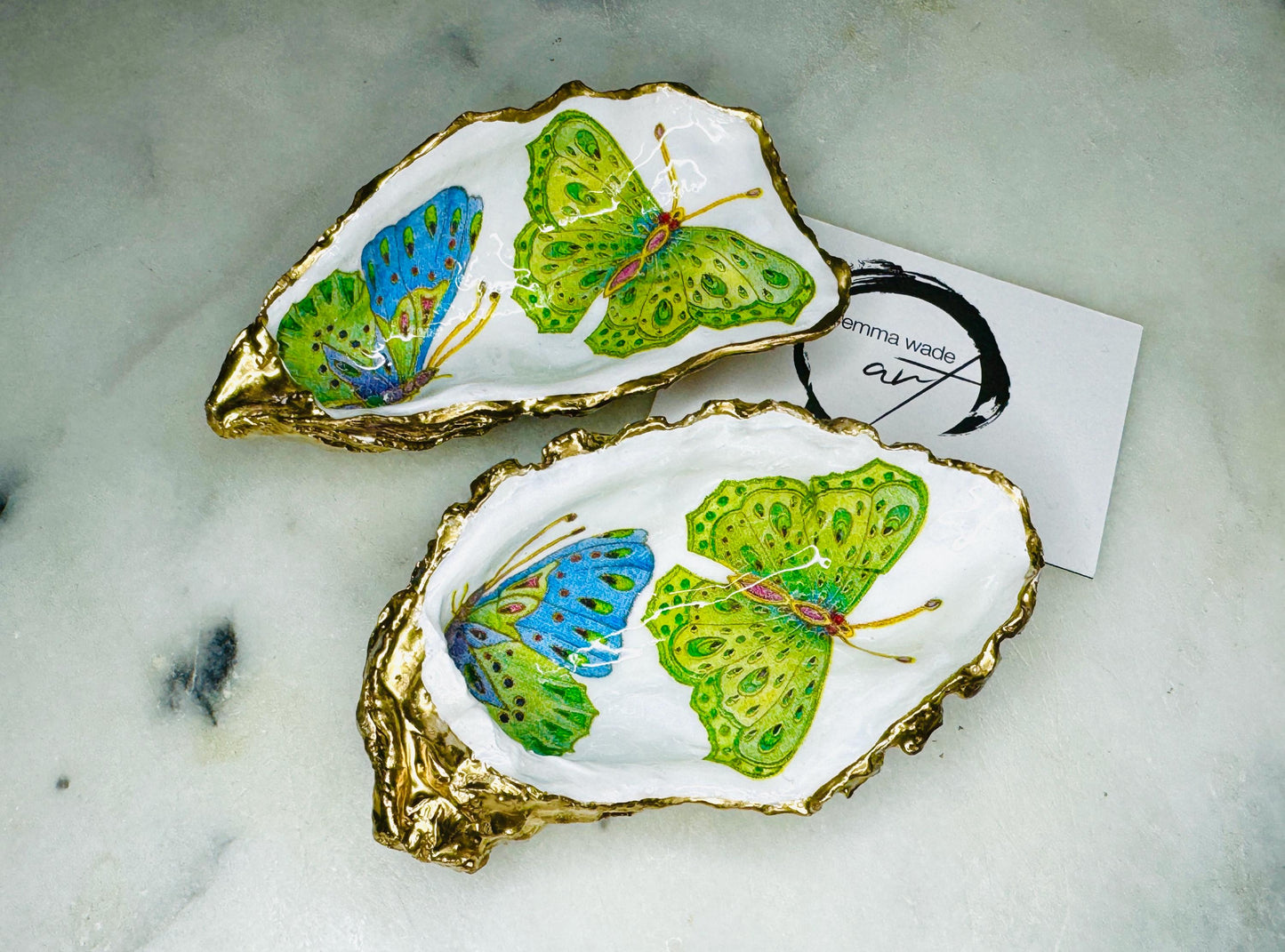 Handmade butterfly oyster shell trinket dish with colourful blue green and pink butterfly designs, edged and backed in gold leaf, Dorset coastal shell jewellery holder with glossy resin finish, luxury ring dish, coastal home decor gift, unique handmade shell dish for jewellery storage, beach house accessory, UK artisan oyster shell dish
