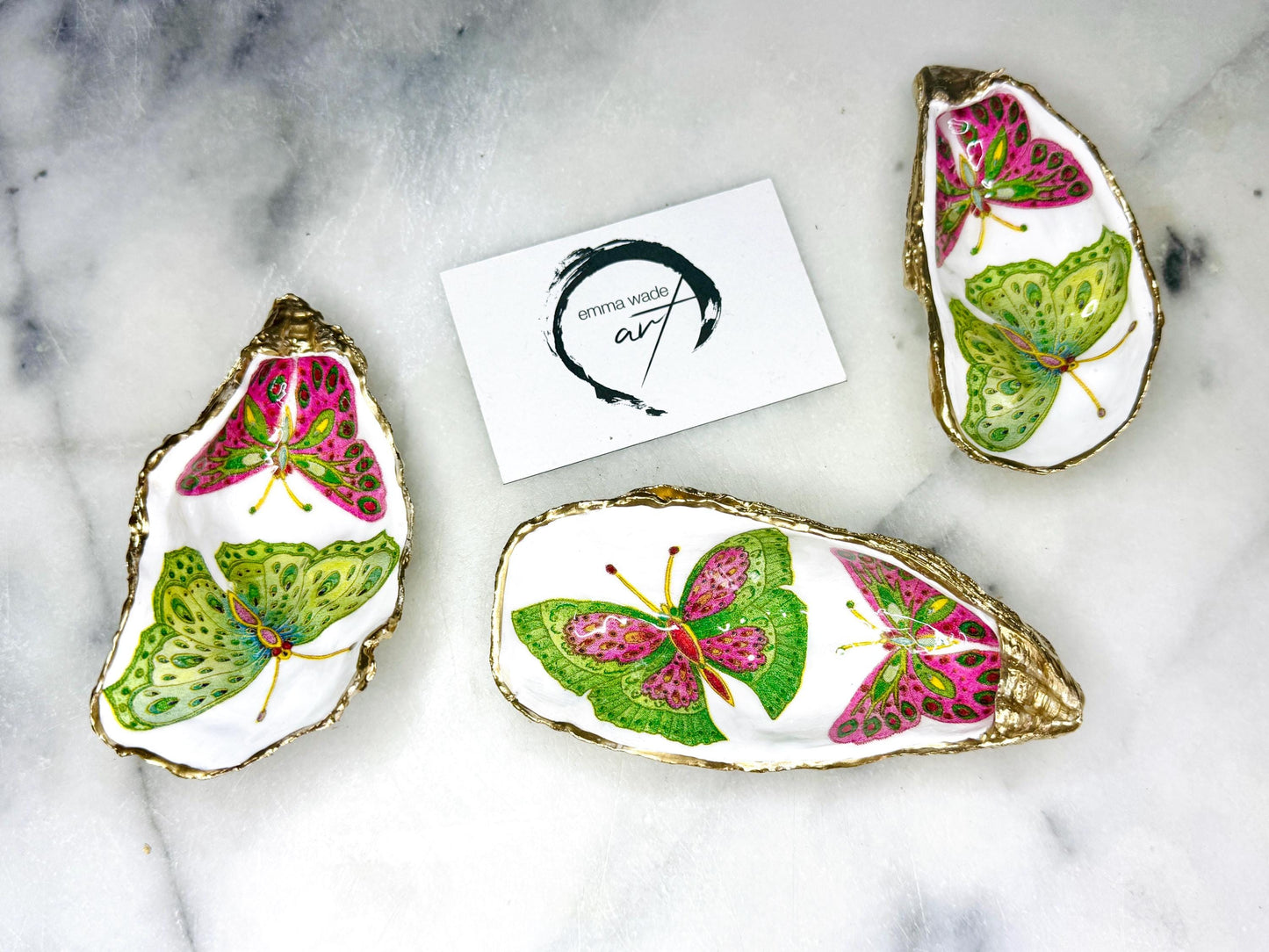 Handmade butterfly oyster shell trinket dish with colourful blue green and pink butterfly designs, edged and backed in gold leaf, Dorset coastal shell jewellery holder with glossy resin finish, luxury ring dish, coastal home decor gift, unique handmade shell dish for jewellery storage, beach house accessory, UK artisan oyster shell dish