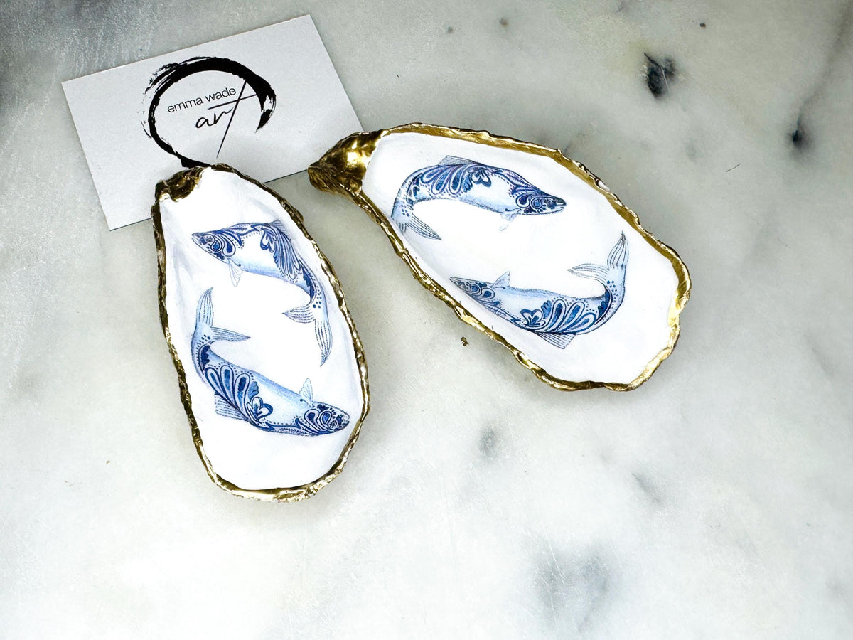 Handmade Dorset oyster shell salt and pepper pinch pots featuring blue paisley fish designs with gold leaf edging and glossy resin finish. Coastal oyster shell cruet set with natural pearlescent interiors and optional gold spoons, styled as elegant nautical table décor and condiment dishes.
