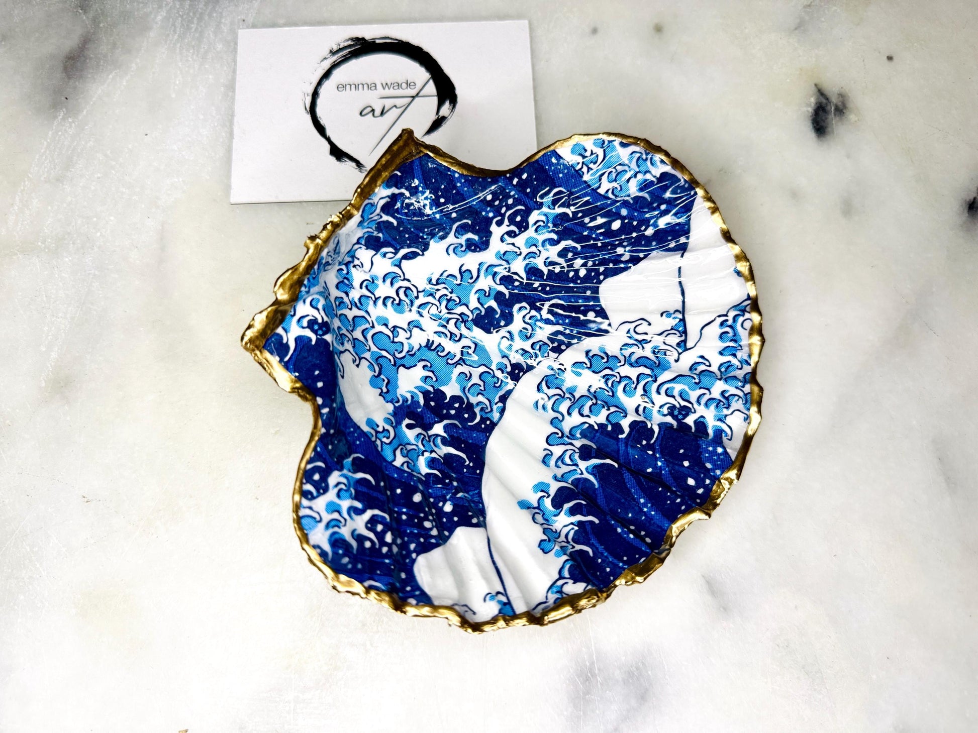 Great Wave of Kanagawa inspired scallop shell trinket dish with deep blue ocean wave artwork, gold leaf edging and glossy resin finish. Handmade coastal jewellery tray and Japanese ocean-inspired ring dish created from a natural Dorset scallop shell.