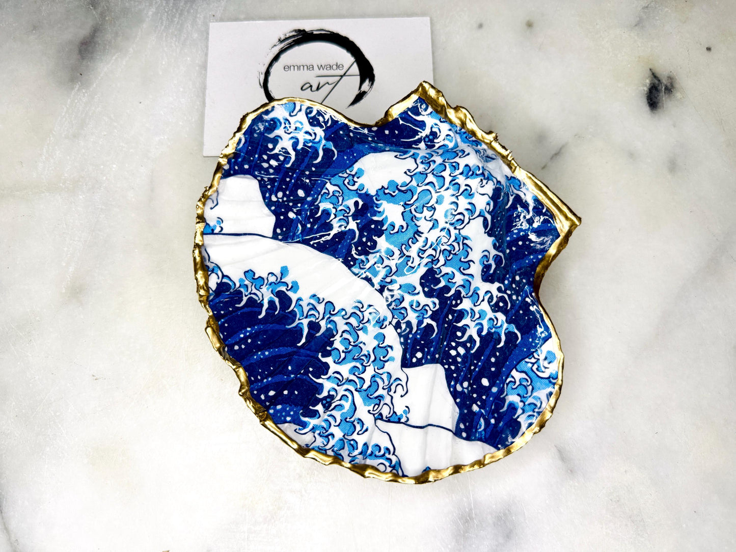 Great Wave of Kanagawa inspired scallop shell trinket dish with deep blue ocean wave artwork, gold leaf edging and glossy resin finish. Handmade coastal jewellery tray and Japanese ocean-inspired ring dish created from a natural Dorset scallop shell.