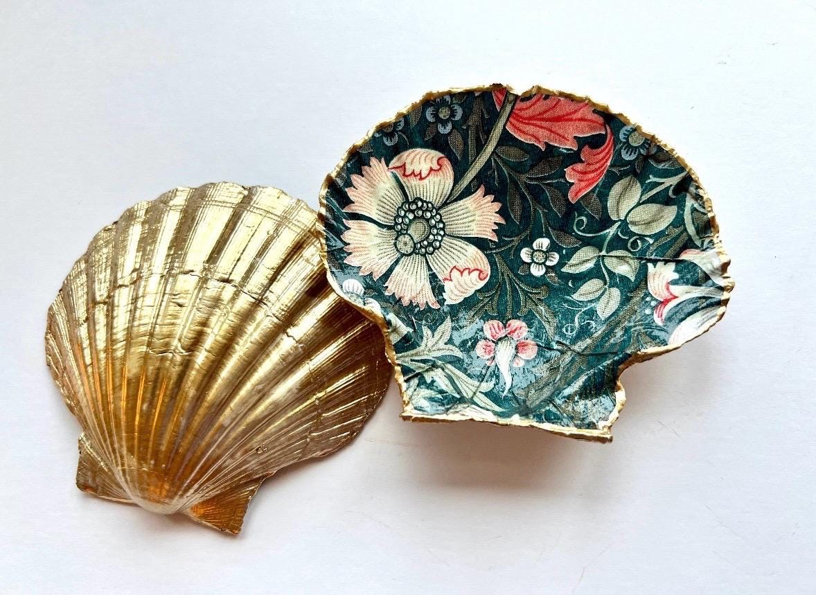 William Morris Compton dark blue scallop shell dish hand finished with liquid gold leaf and sealed with crystal-clear gloss resin. Natural Dorset shell decorated with botanical floral design in blue, green and cream. Available in small 10–11cm or large 12–14cm. Ideal as a jewellery dish, ring holder, trinket tray, cufflink dish, tea light holder or coastal home decor gift.