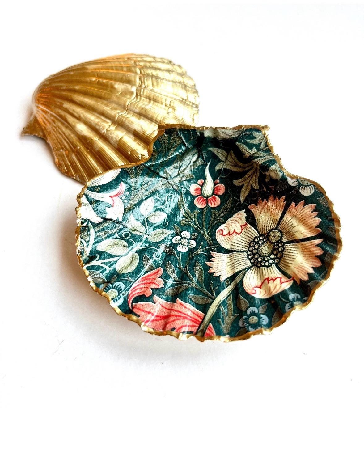 William Morris Compton dark blue scallop shell dish hand finished with liquid gold leaf and sealed with crystal-clear gloss resin. Natural Dorset shell decorated with botanical floral design in blue, green and cream. Available in small 10–11cm or large 12–14cm. Ideal as a jewellery dish, ring holder, trinket tray, cufflink dish, tea light holder or coastal home decor gift.