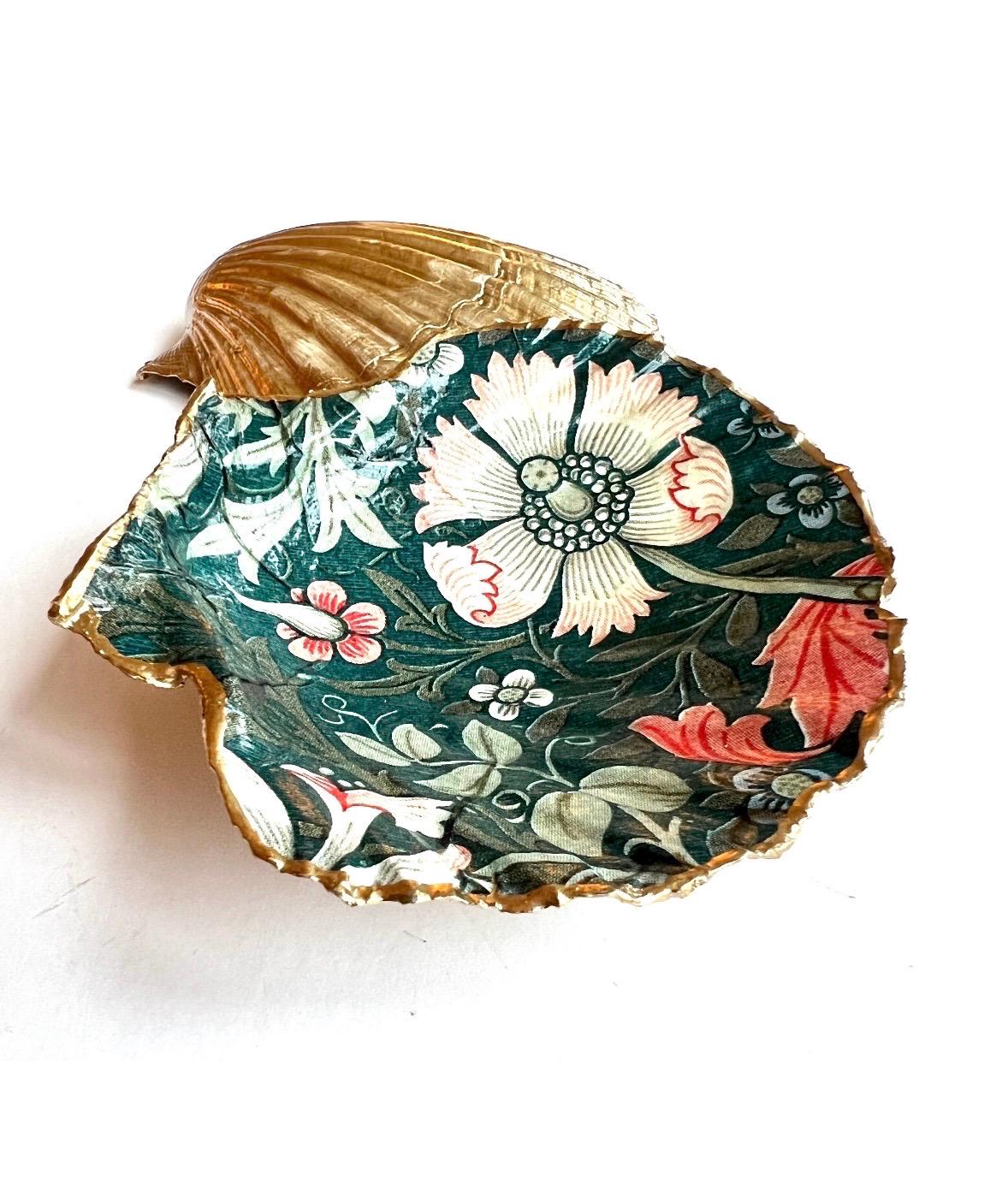 William Morris Compton dark blue scallop shell dish hand finished with liquid gold leaf and sealed with crystal-clear gloss resin. Natural Dorset shell decorated with botanical floral design in blue, green and cream. Available in small 10–11cm or large 12–14cm. Ideal as a jewellery dish, ring holder, trinket tray, cufflink dish, tea light holder or coastal home decor gift.