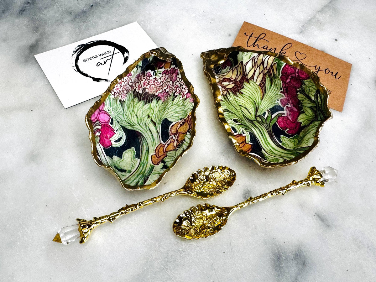Handcrafted pair of oyster shell salt and pepper pinch pots featuring the Forest Trees botanical design in rich green, pink, cream and gold tones. Natural Dorset oyster shells hand-finished with liquid gold leaf edging and sealed beneath a crystal-clear resin for a glossy finish. Includes optional gold crystal spoons. Elegant table decor for dining, entertaining, weddings, anniversaries and housewarming gifts. Handmade in Surrey, England by Emma Wade ART.