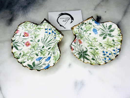 Handcrafted Dorset scallop shell dish featuring William Morris Compton botanical artwork with flowing green foliage and floral details. Natural scallop shell hand-finished with real liquid gold leaf edging and reverse, sealed beneath crystal-clear glossy resin. Luxury jewellery dish, ring holder and trinket tray for coastal, cottagecore and Arts & Crafts inspired interiors. Available in small and large scallop shell sizes.