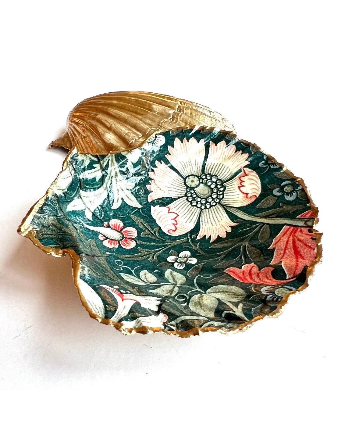 William Morris Compton dark blue scallop shell dish hand finished with liquid gold leaf and sealed with crystal-clear gloss resin. Natural Dorset shell decorated with botanical floral design in blue, green and cream. Available in small 10–11cm or large 12–14cm. Ideal as a jewellery dish, ring holder, trinket tray, cufflink dish, tea light holder or coastal home decor gift.