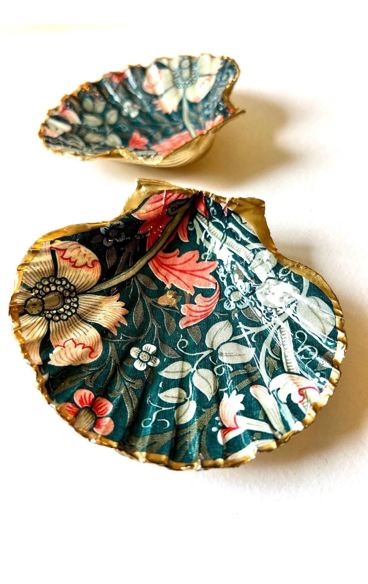 William Morris Compton dark blue scallop shell dish hand finished with liquid gold leaf and sealed with crystal-clear gloss resin. Natural Dorset shell decorated with botanical floral design in blue, green and cream. Available in small 10–11cm or large 12–14cm. Ideal as a jewellery dish, ring holder, trinket tray, cufflink dish, tea light holder or coastal home decor gift.