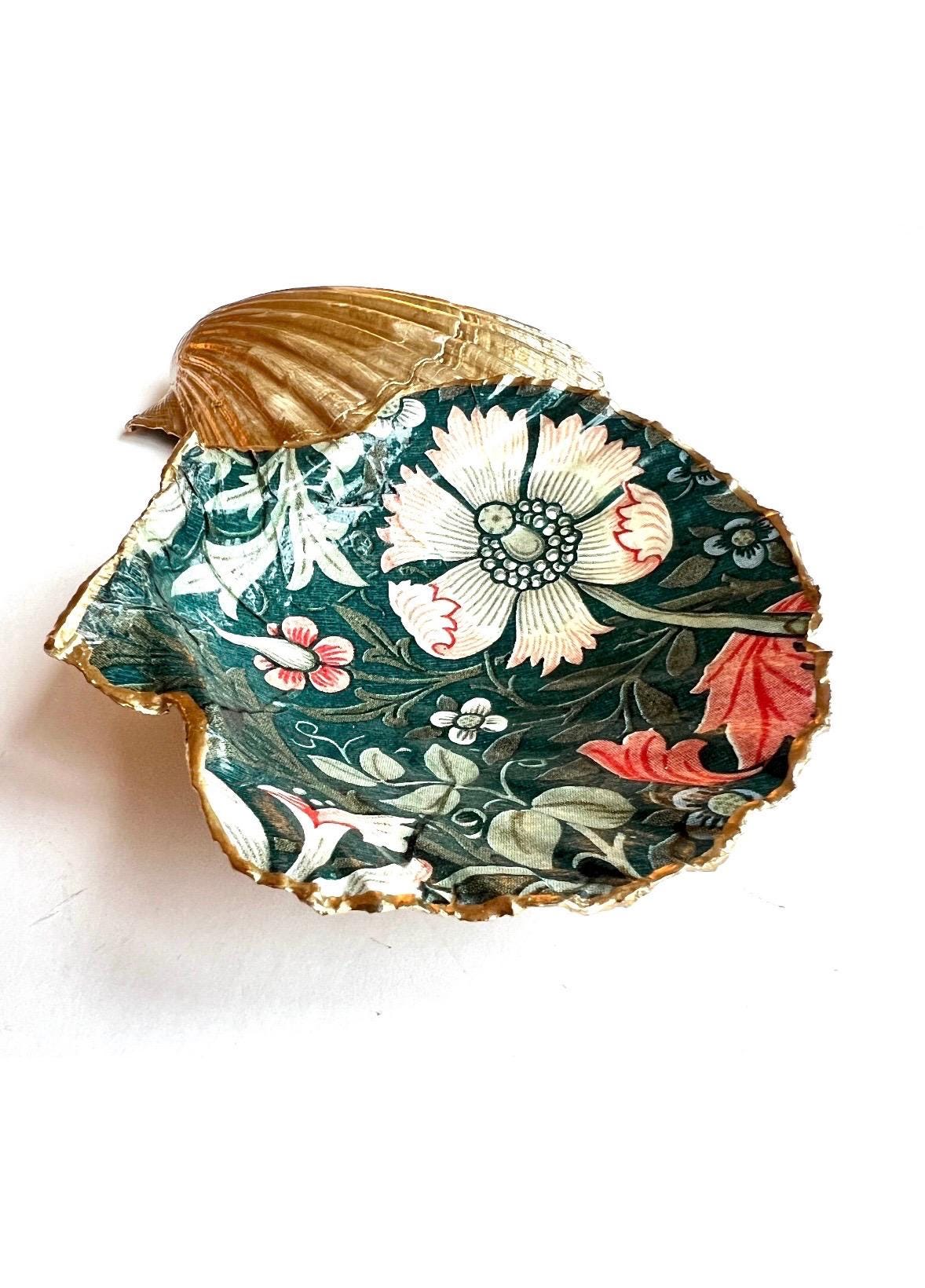 William Morris Compton dark blue scallop shell dish hand finished with liquid gold leaf and sealed with crystal-clear gloss resin. Natural Dorset shell decorated with botanical floral design in blue, green and cream. Available in small 10–11cm or large 12–14cm. Ideal as a jewellery dish, ring holder, trinket tray, cufflink dish, tea light holder or coastal home decor gift.
