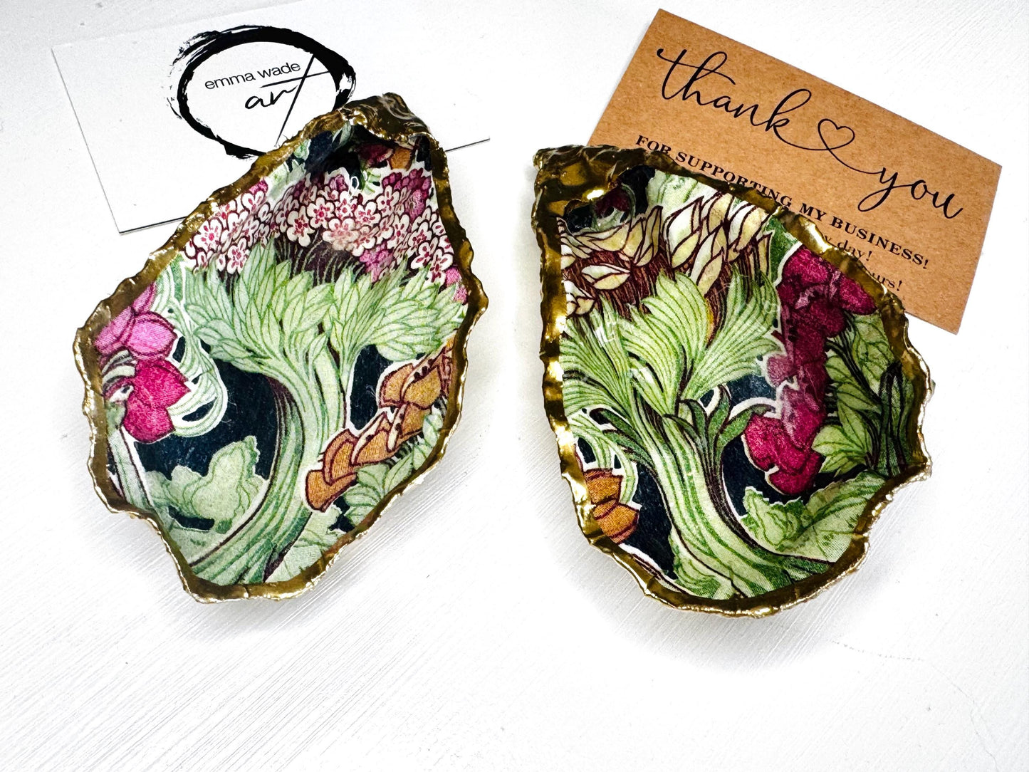 Handcrafted pair of oyster shell salt and pepper pinch pots featuring the Forest Trees botanical design in rich green, pink, cream and gold tones. Natural Dorset oyster shells hand-finished with liquid gold leaf edging and sealed beneath a crystal-clear resin for a glossy finish. Includes optional gold crystal spoons. Elegant table decor for dining, entertaining, weddings, anniversaries and housewarming gifts. Handmade in Surrey, England by Emma Wade ART.