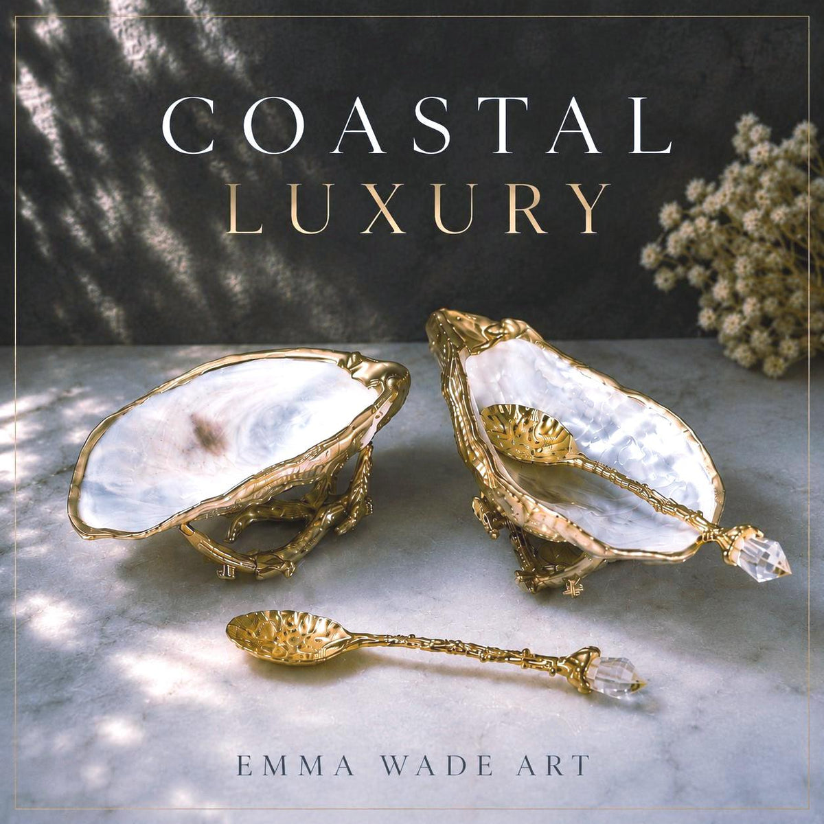 Pair of natural cupped oyster shell salt and pepper dishes displayed on individual driftwood-style gold metal stands. Each oyster shell has a liquid gold leaf rim and glossy resin-sealed pearlescent interior, with a choice of natural gold-highlighted or fully gilded backs. Optional ornate gold spoons with clear crystal ends are shown alongside. Luxury coastal cruet set and wedding or housewarming gift by Emma Wade ART.