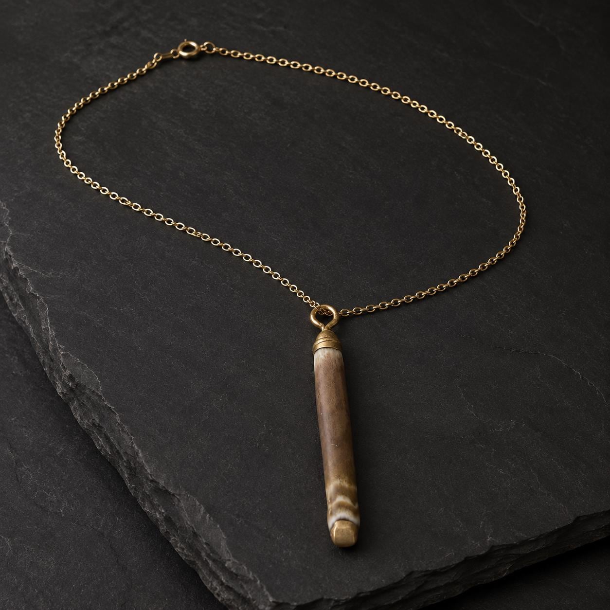 Handmade pencil-urchin spine necklace arranged on a dark luxury background with an 18K gold-plated chain and liquid-gold detail