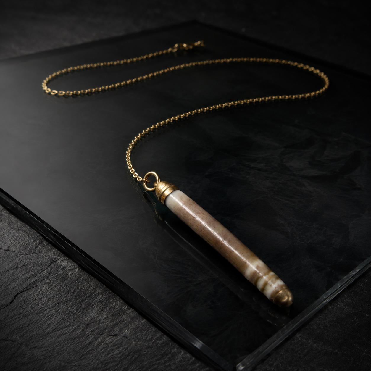 Handmade pencil-urchin spine necklace arranged on a dark luxury background with an 18K gold-plated chain and liquid-gold detail